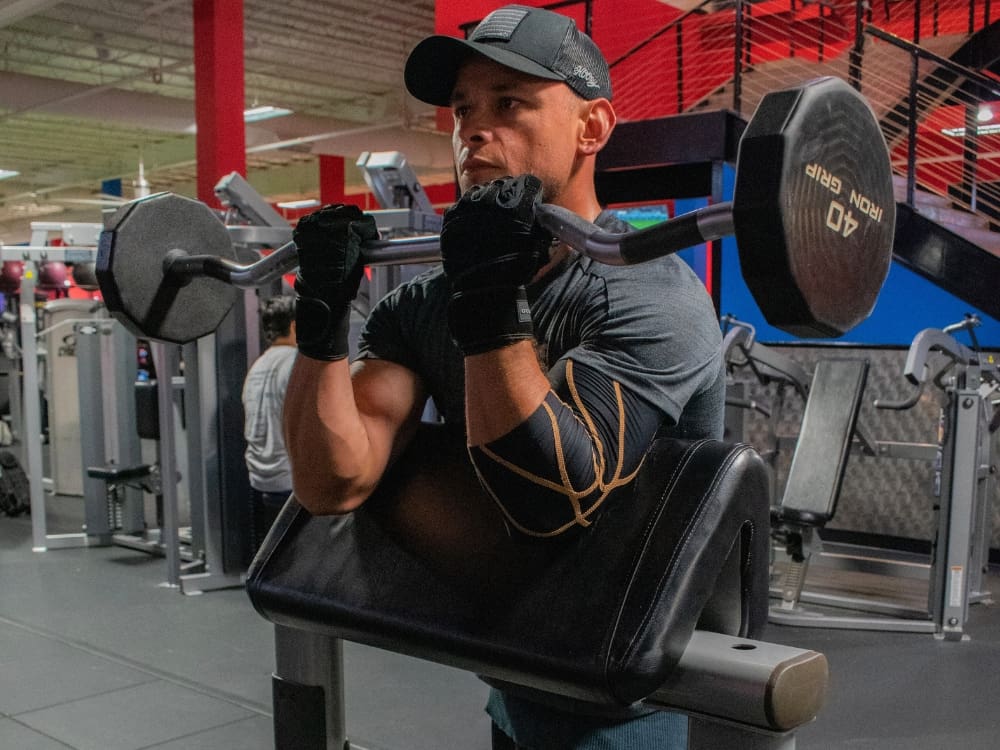 a gym member does a bicep strength training workout using free weights at a gym near me in corpus christi