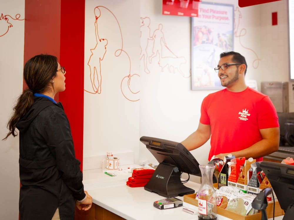 a smoothie bar team member helps a gym member at freedom fitness gym in corpus christi on airline