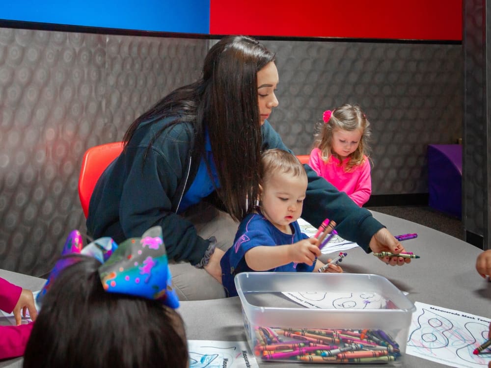 an onsite childcare worker with kids at a gym near me