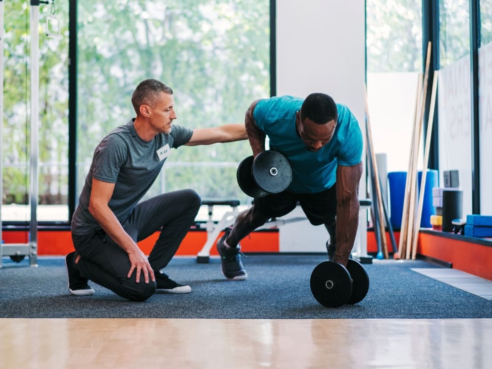 a gym member and personal trainer work out at a freedom fitness gym near me