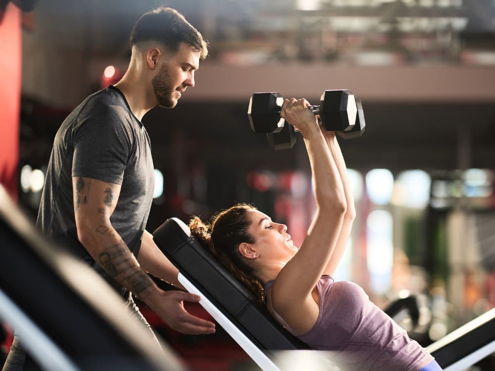 gym members work out with free weights for strength training at a freedom fitness gym in corpus christi airline