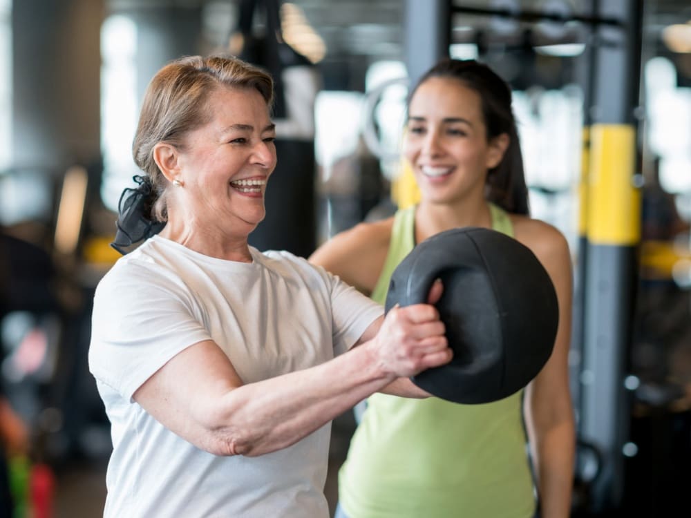 a personal trainer helps a gym member with strength training at an airline corpus christi gym