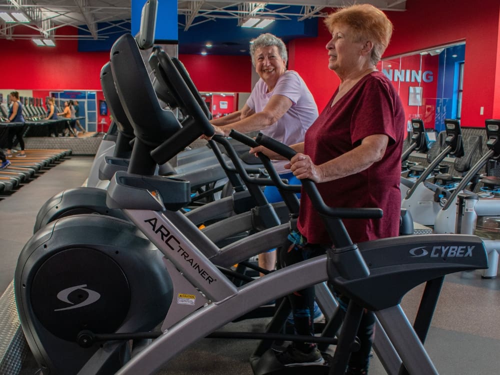 2 ladies use cardio training equipment at a gym near me