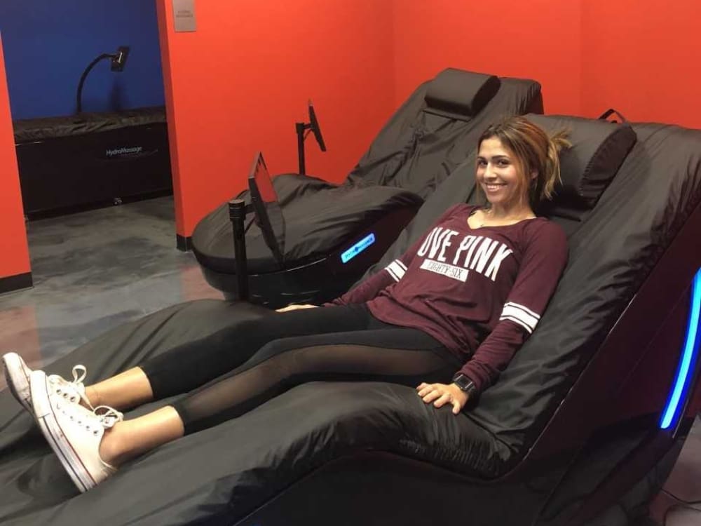 a gym member lays in a hydromassage bed for recovery at a gym near me