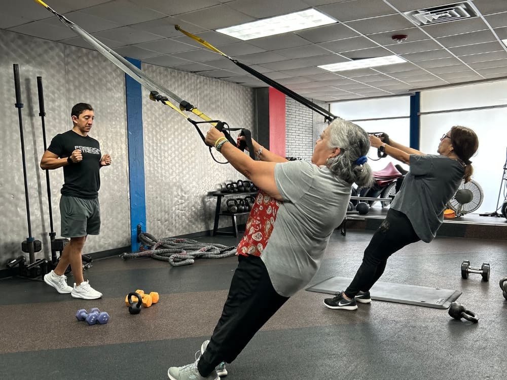 gym members work with a personal trainer at a gym near me