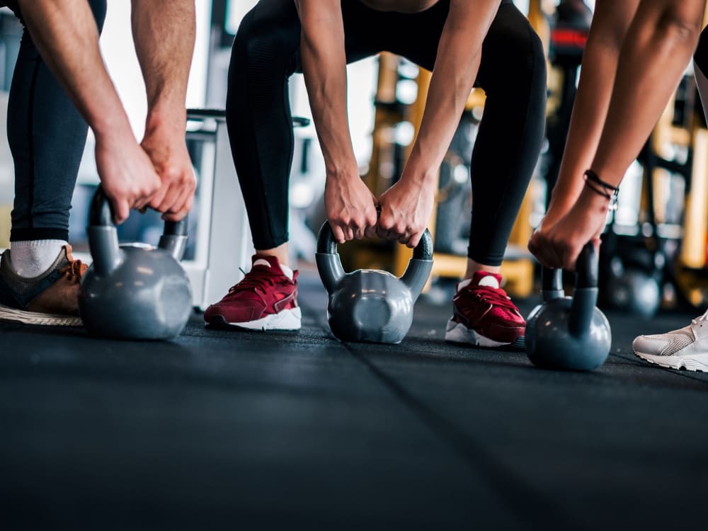 gym members lift kettle bells during small group training session at freedom fitness gym in alameda