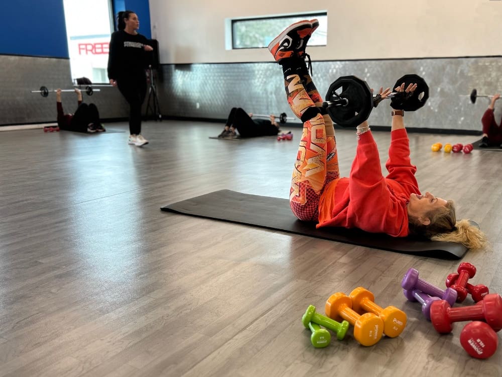 gym members lift barbells during a group fitness class at a gym near me in calallen