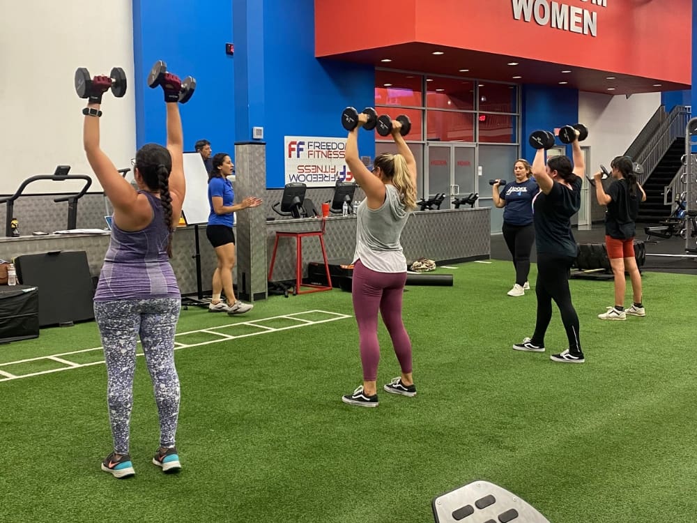 gym members lift dumb bells during a group fitness class at freedom fitness gym in saratoga