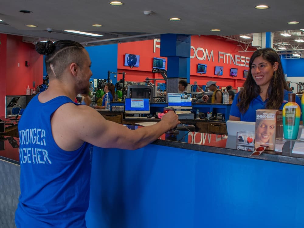 a gym member checks in at the front desk at freedom fitness gym in saratoga