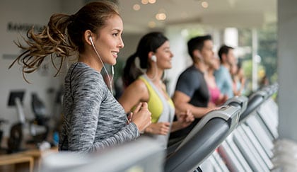 gym members running on cardio treadmills