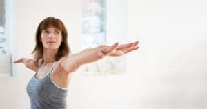 a gym member holds a yoga pose at freedom fitness gym near me