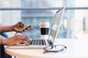 african woman working on laptop and cell phone