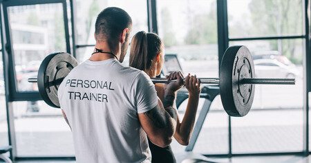 personal trainer assisting health club memeber at fitness center