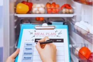 Person doing fridge inventory for fruits and veggies.