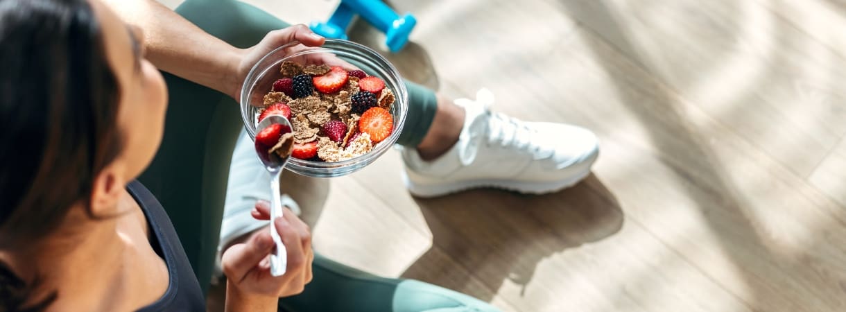 a woman eats a granola bowl for a healthy snack at freedom fitness gym in corpus christi