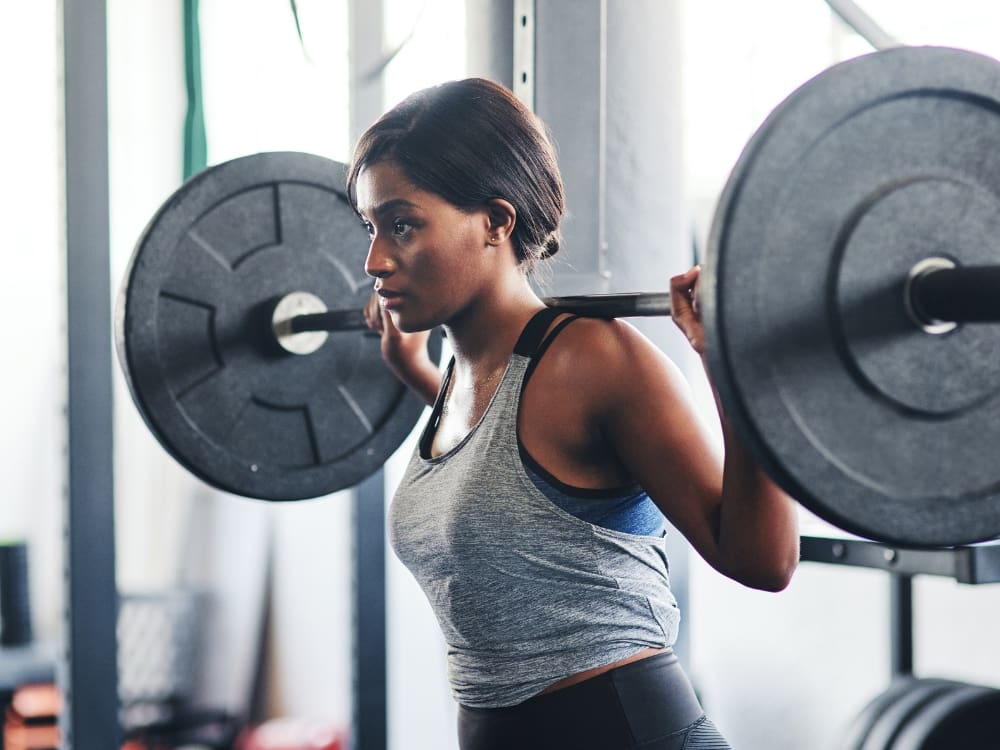 a gym member squats to build muscle at freedom fitness in corpus christi