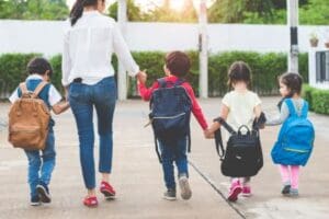 picture of mom walking kids back to school