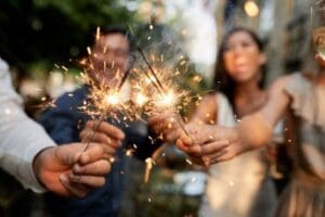 Friends holding sparklers together during a summer celebration, representing community and healthy living at our Corpus Christi gyms.