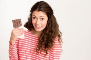 Woman enjoying chocolate while maintaining a balanced fitness routine at our Corpus Christi gyms.