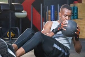 Man doing a medicine ball core exercise at our Corpus Christi gym.